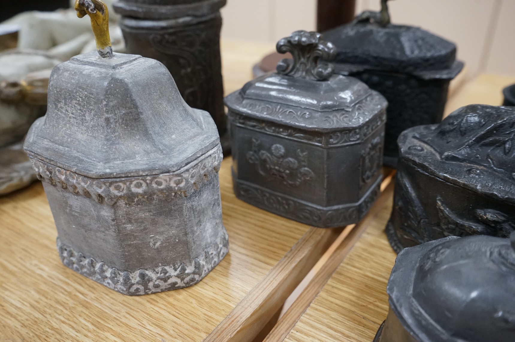 A collection of eleven early 19th century lead tobacco boxes to include an octagonal example with remains of red paint, largest 13cm wide